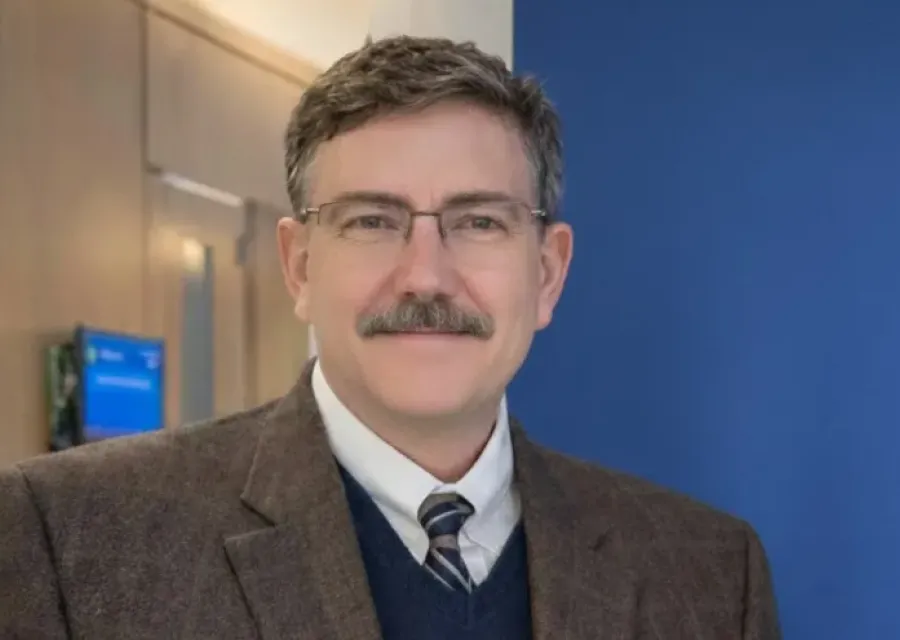 Photo of a man standing inside an office. 