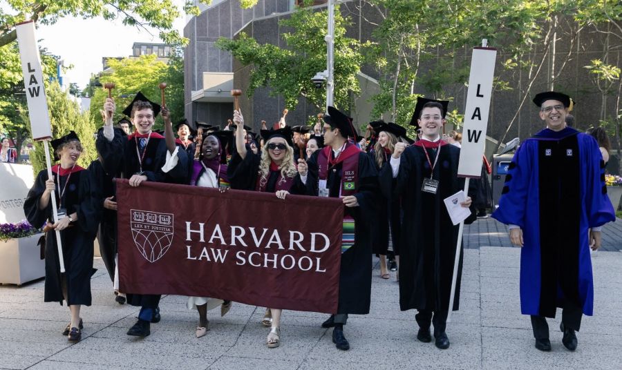 Group of students carrying a Harvard Law School banner.