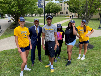 students and faculty wearing canisius hats on the quad of canisius university
