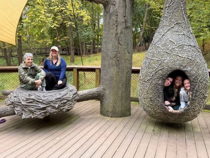 students and faculty gathering at a display outside of a zoo