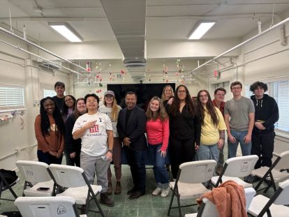 A group of students standing with a former Border Patrol Agent