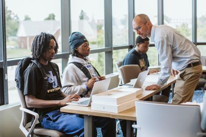 Photo of new students setting up their MacBook Airs