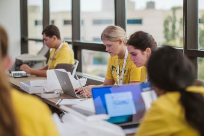 Students sit in front of their new MacBook Air laptops.
