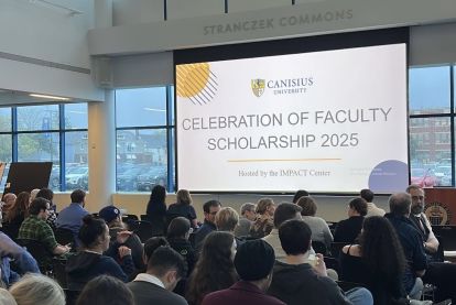 Faculty sharing research in a crowded college meeting area