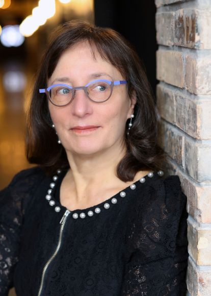 an author poses against a brick wall looking away for a publicity photo